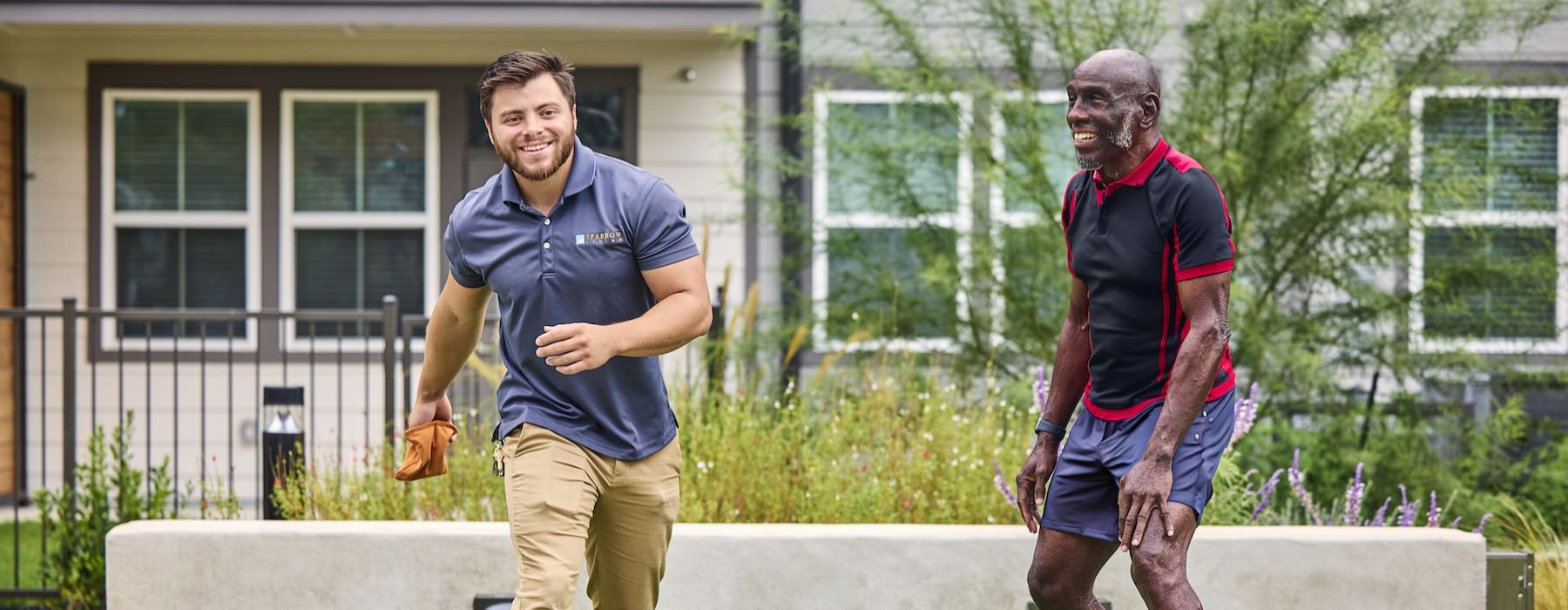 a couple of men playing cornhole