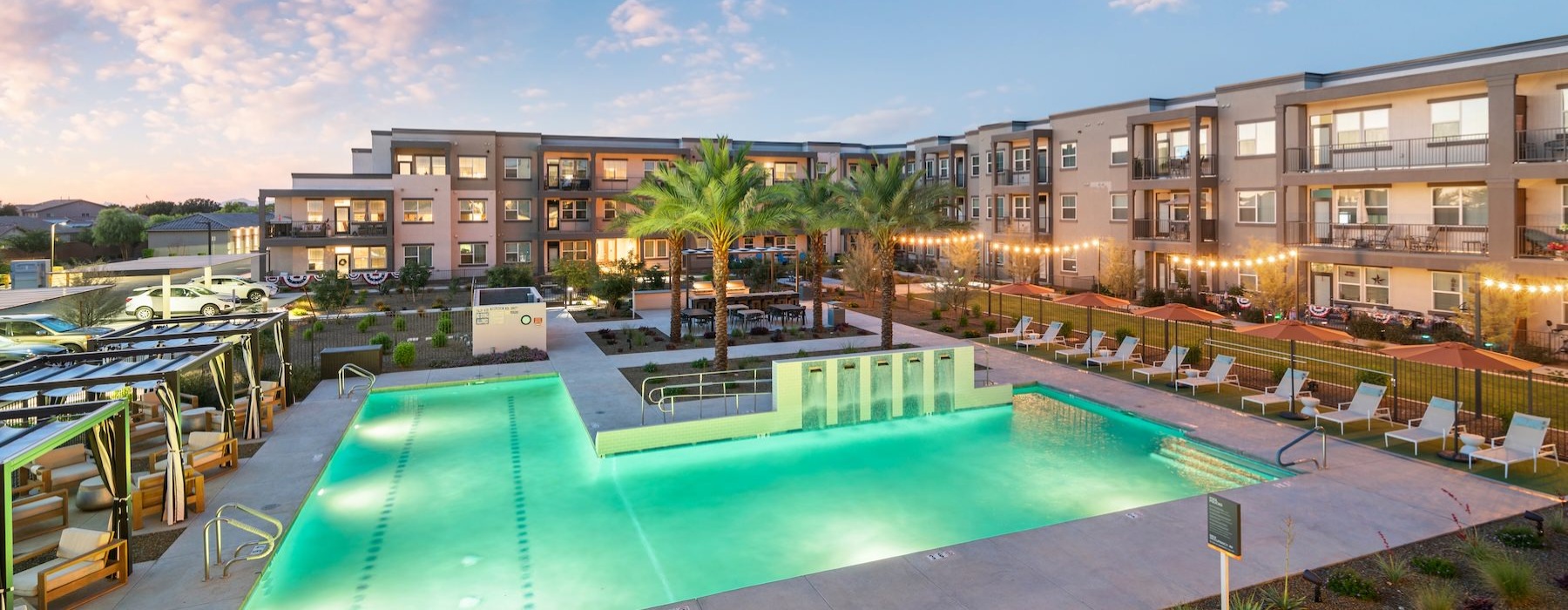 a swimming pool with chairs and umbrellas next to a building
